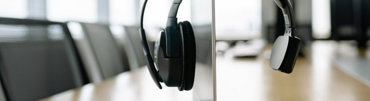 a black headset microphone hanging on the laptop screen